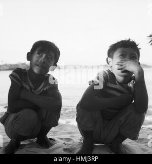 Jungen Hocken bin Strang Bei Canaima Venezuela 1966. Jungs hocken am Strand in der Nähe von Canaima (Venezuela), 1966. Stockfoto