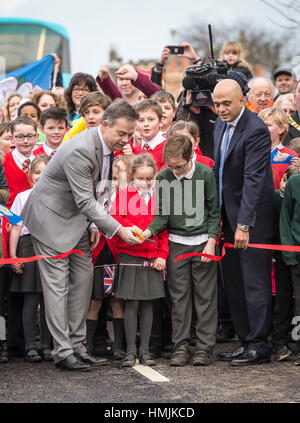 Hinweis alternative Ernte lokalen MP Nigel Adams (links), Gemeinschaften Sekretär Sajid Javid und lokalen Schulkindern an der wiedereröffneten Tadcaster Brücke mehr als ein Jahr nach seiner teilweisen Zusammenbruch kam um die Zerstörung der 2015 Weihnachten Überschwemmungen zu symbolisieren. Stockfoto