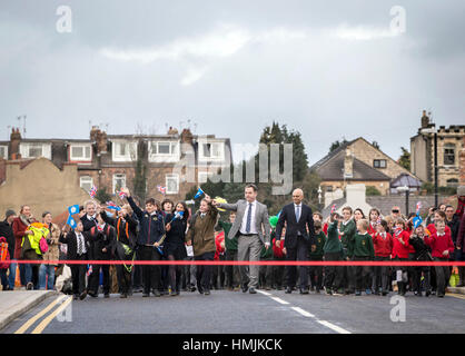 Lokalen MP Nigel Adams (Mitte links), Gemeinschaften Sekretär Sajid Javid und lokalen Schulkindern an der wiedereröffneten Tadcaster Brücke mehr als ein Jahr nach seiner teilweisen Zusammenbruch kam um die Zerstörung der 2015 Weihnachten Überschwemmungen zu symbolisieren. Stockfoto