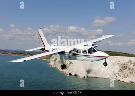 Australien - Queensland Polizei Britten Norman BN-2 b-20 Islander fliegen über das Meer und die Klippen Stockfoto