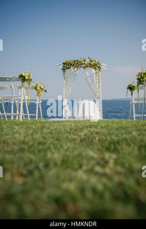 Hochzeit Zeremonie Blumen, Bogen, Stühle mit schwarzen Meer im Hintergrund. Strand Hochzeit Stockfoto