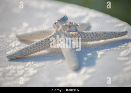 Hochzeit-Gläser und Ringe an den Muscheln und Seesterne. Tabelle mit Spitze. Stockfoto