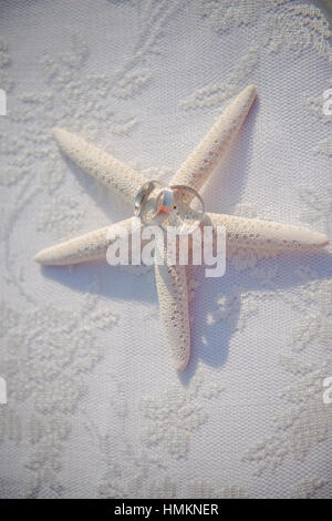 Hochzeit-Gläser und Ringe an den Muscheln und Seesterne. Tabelle mit Spitze. Stockfoto