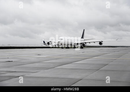 Flugzeug auf der Rollbahn mit einem anderen Jet auf der Piste im Hintergrund abheben Stockfoto