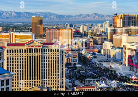 Las Vegas Stadtbild im Sonnenuntergang mit Caesars Palace, The Mirage, Treasure Island, das Cosmopolitan Casino, mit Bergen im Hintergrund entnommen. Stockfoto