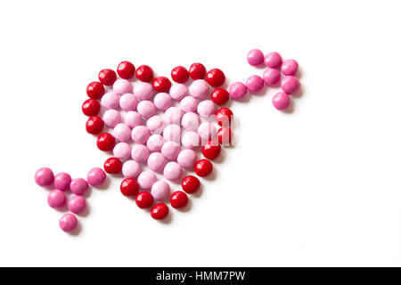 Bunten roten und rosa Süßigkeiten ein Herz geformt, mit einem Pfeil auf einem weißen Hintergrund isoliert Stockfoto