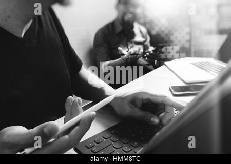 Coworking-Prozess, Unternehmer-Team arbeitet in kreativen Büroräume. Verwendung von digital-Tablette Docking-Tastatur und Laptop mit Smartphone auf Marmor Tisch, Stockfoto