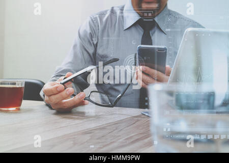 Erfolg Geschäftsmann Hand mit Brillen, Smartphone, Digital tablet Docking-smart-Tastatur auf Holz Schreibtisch Stockfoto