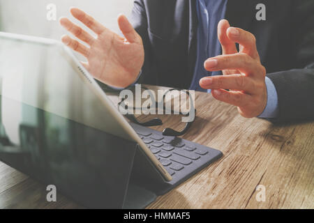 Erfolg Geschäftsmann Hand mit Brillen, digital-Tablette Docking-smart-Tastatur auf Holz Schreibtisch, Filter-Effekt Stockfoto