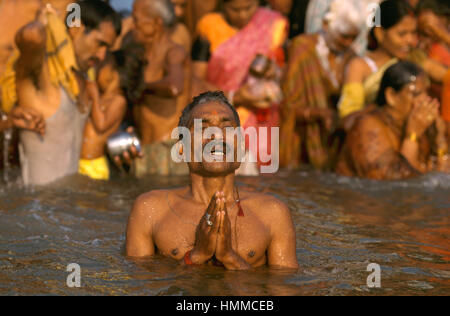 Mann beim Gebet in den Fluss Ganges in Varanasi während des Kartik Purnima Festivals in Indien Stockfoto