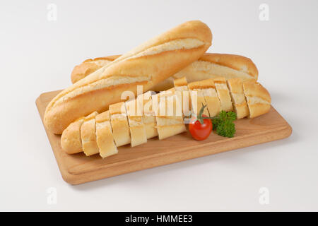 ganze und geschnittene französischen Baguettes auf Holzbrett Stockfoto