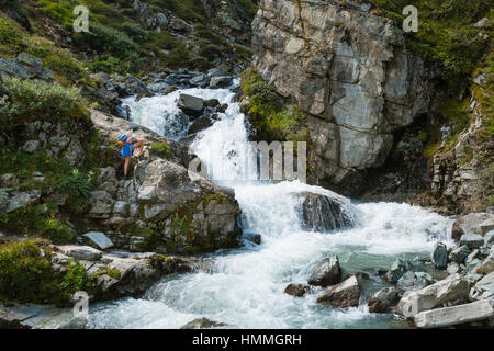 SILVRETTA - 13 AUGUST: Eine junge Frau in Wanderbekleidung gerade einen Berg-Wasserfall in der Silvretta Region, Austriay am 13. August 2015. Stockfoto