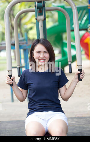 Asiatische Frau Teen schwarze Haare glücklich Lächeln mit Sport Brust Heimtrainer im Park genießen. Stockfoto