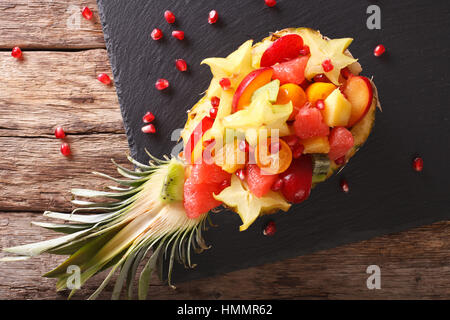 Reifer Ananas gefüllt mit frischen tropischen Früchten Nahaufnahme auf dem Tisch. horizontale Ansicht von oben Stockfoto