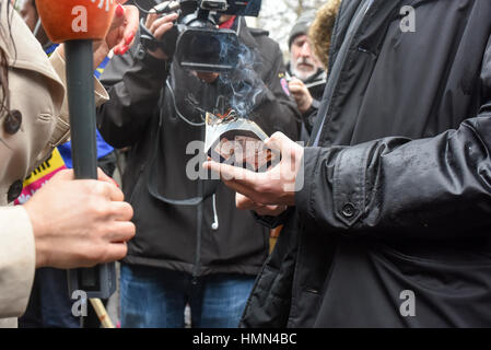 London, UK. 4. Februar 2017. Bei einem Protest gegen Donald Trump in Grosvenor Square brennt ein Mann seine US-Pass. Tausende von Demonstranten gegen Trumps Einwanderung Verbot versammelten sich vor der US-Botschaft in Grosvenor Square und marschierten zur Downing Street. Bildnachweis: Jacob Sacks-Jones/Alamy Live-Nachrichten. Stockfoto