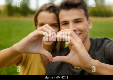 Porträt eines jungen schönen Paares in der Liebe ein Herz mit ihren Händen machen Stockfoto