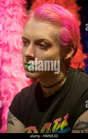 Porträt einer jungen Frau von Transgender mit rosa Haaren, rosa Augen Make-up und grünen Lippenstift gestellt. Im Zentrum von Manhattan, New York City Stockfoto