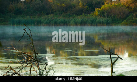 Alten Niederlassung und Morgen Nebel über der Oberfläche des Sees Stockfoto