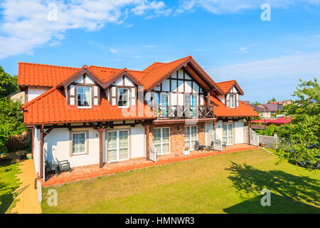 LEBA, Polen - 20. Juni 2016: typisches Haus gebaut im Stil der kaschubischen im grünen Garten in der Stadt Leba, Ostsee, Polen. Stockfoto