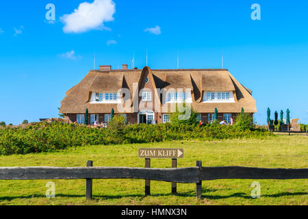 Melden Sie auf der grünen Wiese zeigt Richtung Morsum Kliff mit typischen Restaurant Gebäude im Hintergrund die Insel Sylt, Deutschland Stockfoto