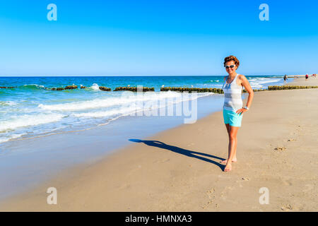 Junge attraktive Frau stehen auf sandigen Strand, Insel Sylt, Deutschland Stockfoto