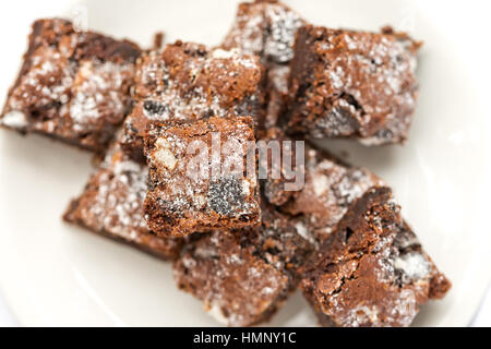 Leckere frisch gebackene hausgemachte Kekse und Creme Brownie-Stücke auf einem weißen Teller. Selektiven Fokus auf der Oberseite brownie Stockfoto