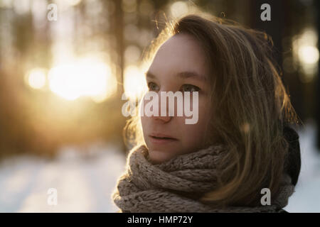 Teenager-Mädchen Porträt im Winter Kiefernwald ist der Sonnenuntergang Stockfoto