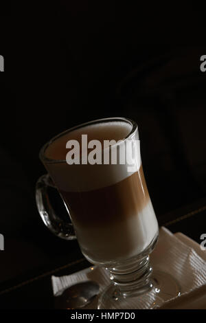 Kaffee Latte aus transparentem Glas auf dunklem Hintergrund mit Exemplar Stockfoto