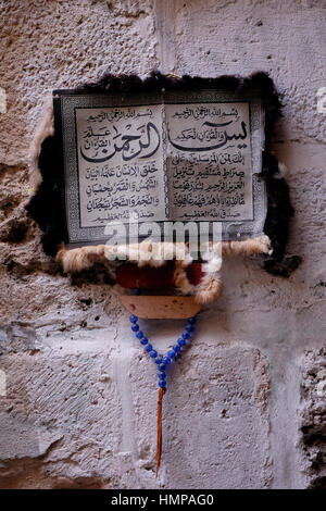 Verse aus dem religiösen islamischen Koran oder den Koran auf Arabisch über ein Pergament gemacht von Ziegenleder erhängt in der Wand in einer Gasse in der muslimischen Viertel Altstadt Ost-Jerusalem Israel Stockfoto