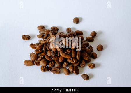 Kleine Haufen von gerösteten Kaffeebohnen auf weißem Hintergrund Stockfoto