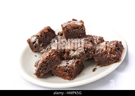 Leckere frisch gebackene hausgemachte Kekse und Creme Brownie-Stücke auf einem weißen Teller. Selektiven Fokus auf der Oberseite brownie Stockfoto