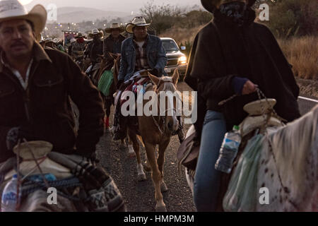 Hunderte von mexikanischen Cowboys beginnen eine Tag lang Fahrt im Morgengrauen während der jährlichen Wallfahrt Cabalgata de Cristo Rey 5. Januar 2017 in La Sauceda, Guanajuato, Mexiko. Tausende von mexikanischen Cowboys und Pferd beteiligen sich die drei-Tages-Fahrt zum Berggipfel Schrein des Cristo Rey stoppen auf dem Weg an Schreinen und Kirchen. Stockfoto