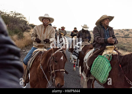 Hunderte von mexikanischen Cowboys beginnen eine Tag lang Fahrt im Morgengrauen während der jährlichen Wallfahrt Cabalgata de Cristo Rey 5. Januar 2017 in La Sauceda, Guanajuato, Mexiko. Tausende von mexikanischen Cowboys und Pferd beteiligen sich die drei-Tages-Fahrt zum Berggipfel Schrein des Cristo Rey stoppen auf dem Weg an Schreinen und Kirchen. Stockfoto