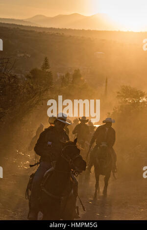 Hunderte von mexikanischen Cowboys beginnen eine Tag lang Fahrt bei Sonnenaufgang während der jährlichen Wallfahrt Cabalgata de Cristo Rey 5. Januar 2017 in La Sauceda, Guanajuato, Mexiko. Tausende von mexikanischen Cowboys und Pferd beteiligen sich die drei-Tages-Fahrt zum Berggipfel Schrein des Cristo Rey stoppen auf dem Weg an Schreinen und Kirchen. Stockfoto