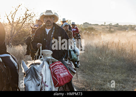 Hunderte von mexikanischen Cowboys beginnen eine Tag lang Fahrt bei Sonnenaufgang während der jährlichen Wallfahrt Cabalgata de Cristo Rey 5. Januar 2017 in San José del Rodeo, Guanajuato, Mexiko. Tausende von mexikanischen Cowboys und Pferd beteiligen sich die drei-Tages-Fahrt zum Berggipfel Schrein des Cristo Rey stoppen auf dem Weg an Schreinen und Kirchen. Stockfoto