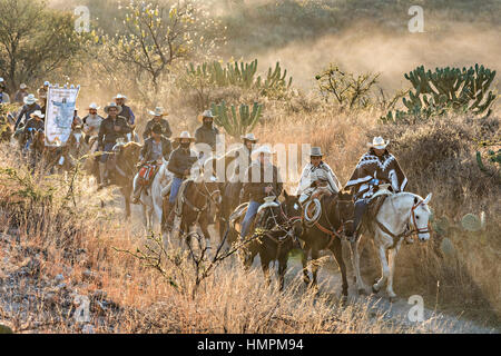 Hunderte von mexikanischen Cowboys beginnen eine Tag lang Fahrt bei Sonnenaufgang während der jährlichen Wallfahrt Cabalgata de Cristo Rey 5. Januar 2017 in San José del Rodeo, Guanajuato, Mexiko. Tausende von mexikanischen Cowboys und Pferd beteiligen sich die drei-Tages-Fahrt zum Berggipfel Schrein des Cristo Rey stoppen auf dem Weg an Schreinen und Kirchen. Stockfoto