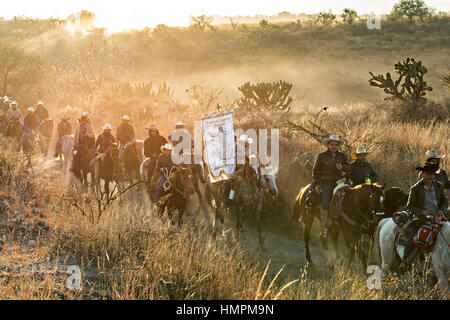 Hunderte von mexikanischen Cowboys beginnen eine Tag lang Fahrt bei Sonnenaufgang während der jährlichen Wallfahrt Cabalgata de Cristo Rey 5. Januar 2017 in San José del Rodeo, Guanajuato, Mexiko. Tausende von mexikanischen Cowboys und Pferd beteiligen sich die drei-Tages-Fahrt zum Berggipfel Schrein des Cristo Rey stoppen auf dem Weg an Schreinen und Kirchen. Stockfoto