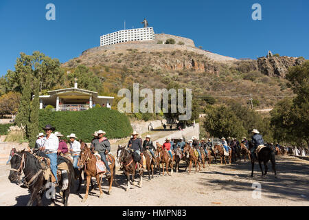 Mexikanische Cowboys kommen für die katholische Messe am Klondike Mountain am Ende der jährlichen Wallfahrt Cabalgata de Cristo Rey 6. Januar 2017 in Guanajuato, Mexiko. Tausende von mexikanischen Cowboys und Pferd beteiligen sich die drei-Tages-Fahrt zum Berggipfel Schrein des Cristo Rey. Stockfoto