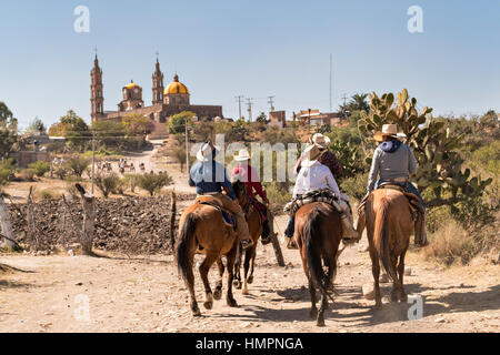 Mexikanische Cowboys kommen für die erste katholische Messe in der Kirche San Martin de Terreros während der jährlichen Wallfahrt Cabalgata de Cristo Rey 4. Januar 2017 in Guanajuato, Mexiko. Tausende von mexikanischen Cowboys und Pferd beteiligen sich die drei-Tages-Fahrt zum Berggipfel Schrein des Cristo Rey stoppen auf dem Weg an Schreinen und Kirchen. Stockfoto