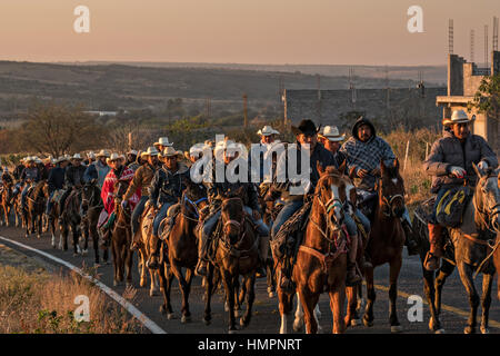 Hunderte von mexikanischen Cowboys beginnen eine Tag lang Fahrt im Morgengrauen während der jährlichen Wallfahrt Cabalgata de Cristo Rey 5. Januar 2017 in La Sauceda, Guanajuato, Mexiko. Tausende von mexikanischen Cowboys und Pferd beteiligen sich die drei-Tages-Fahrt zum Berggipfel Schrein des Cristo Rey stoppen auf dem Weg an Schreinen und Kirchen. Stockfoto