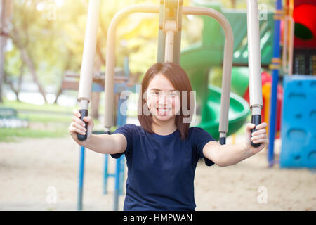 Asiatische Frau Teen schwarze Haare glücklich Lächeln mit Sport Brust Heimtrainer im Park genießen. Stockfoto