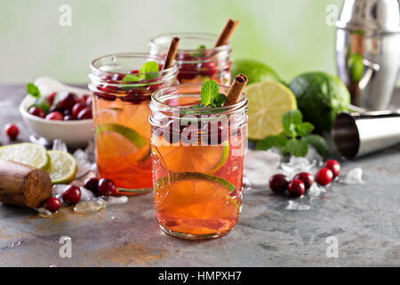Erfrischender cocktail mit Eis, Limette und Cranberry in Einweckgläser winter Stockfoto