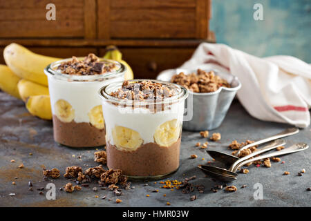Schokolade Chia Pudding Parfait mit Banane, Müsli und Joghurt Stockfoto