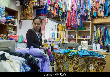 Eine Schneiderin wird in ihrem Geschäft unter Kleidern in Bandar Seri Begawan, Darussalam, Brunei gesehen. © Time-Snaps Stockfoto