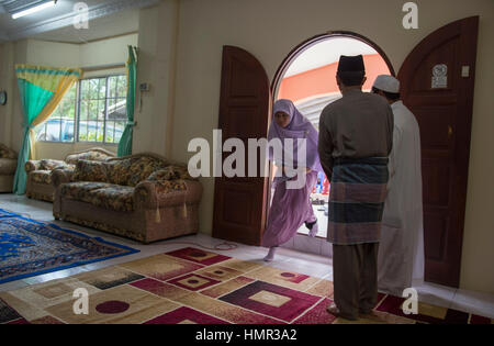 Eine Frau betritt das Haus der Familie vor der Einweihungszeremonie eines konvertierten Mannes in der Nähe von Menangah im Zentrum von Brunei. © Time-Snaps Stockfoto