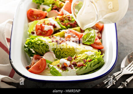 Keil-Salat mit Baby-Salat, Kirschtomaten, Speck und ranch Dressing Gießen über Stockfoto