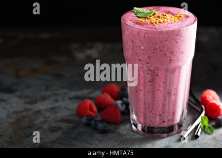 Beeren-Smoothie in ein Longdrinkglas auf dunklem Hintergrund Stockfoto