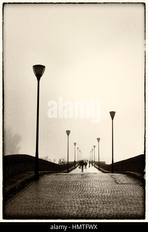 Merida, Extremadura, Spanien.  Nebligen Sonnenuntergang über die Römerbrücke. Stockfoto