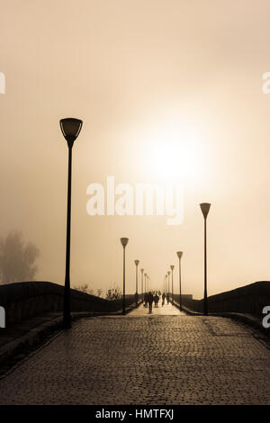 Merida, Extremadura, Spanien.  Nebligen Sonnenuntergang über die Römerbrücke. Stockfoto