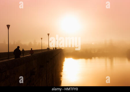 Merida, Extremadura, Spanien.  Nebligen Sonnenuntergang über die Römerbrücke. Stockfoto